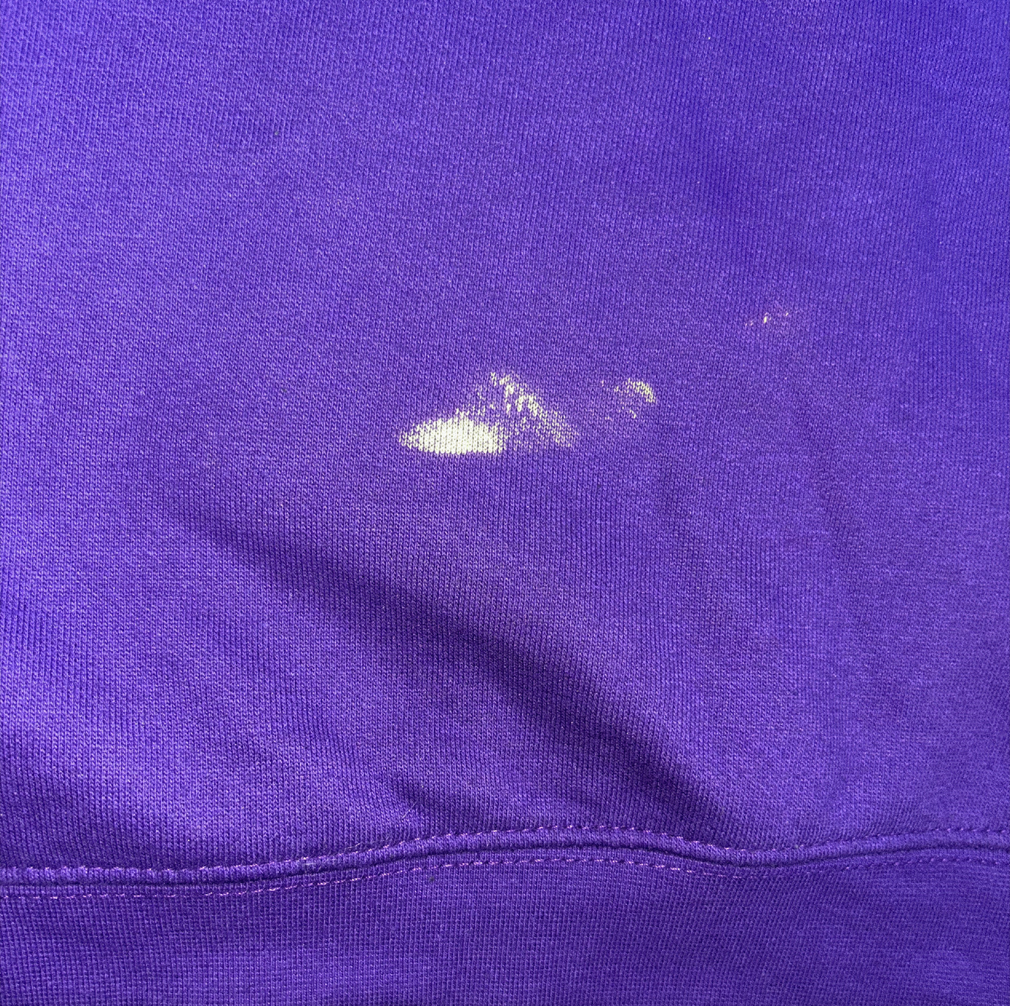 Close-up of a purple fabric with a small white spot