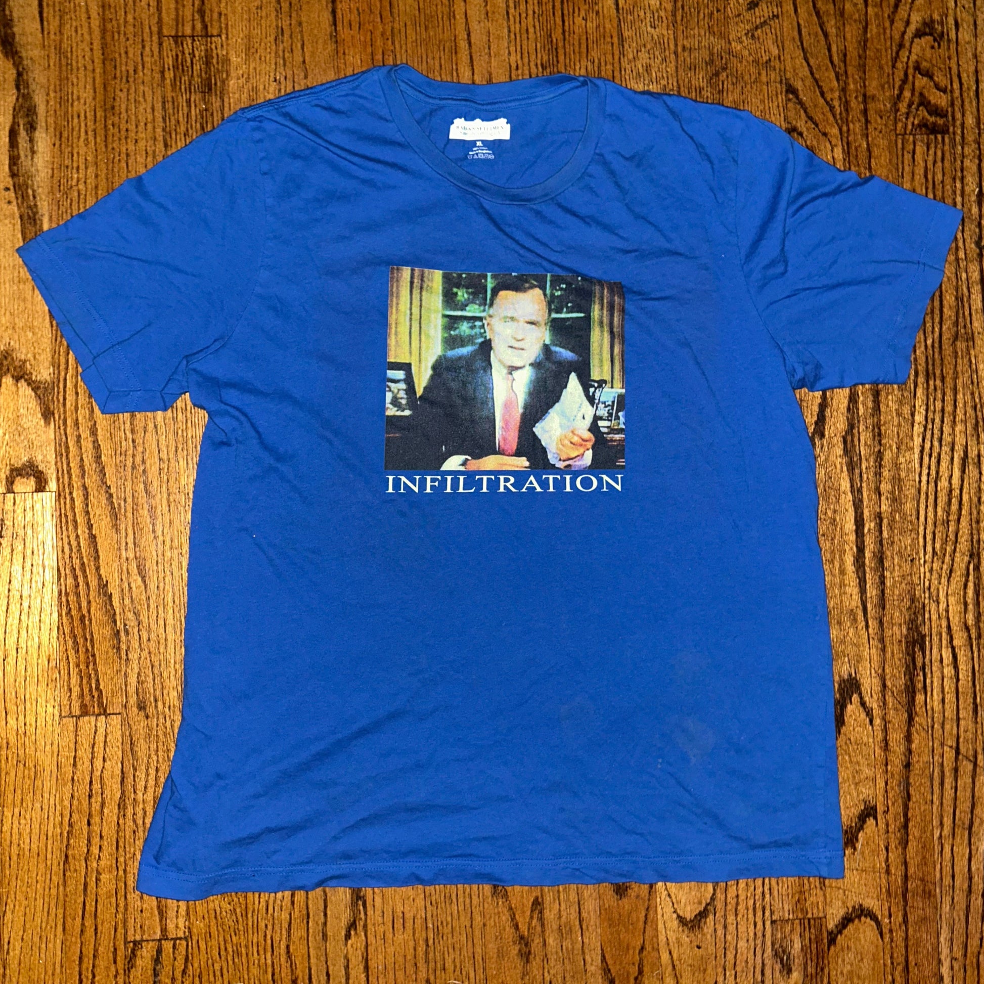 Blue t-shirt with a graphic design on a wooden surface