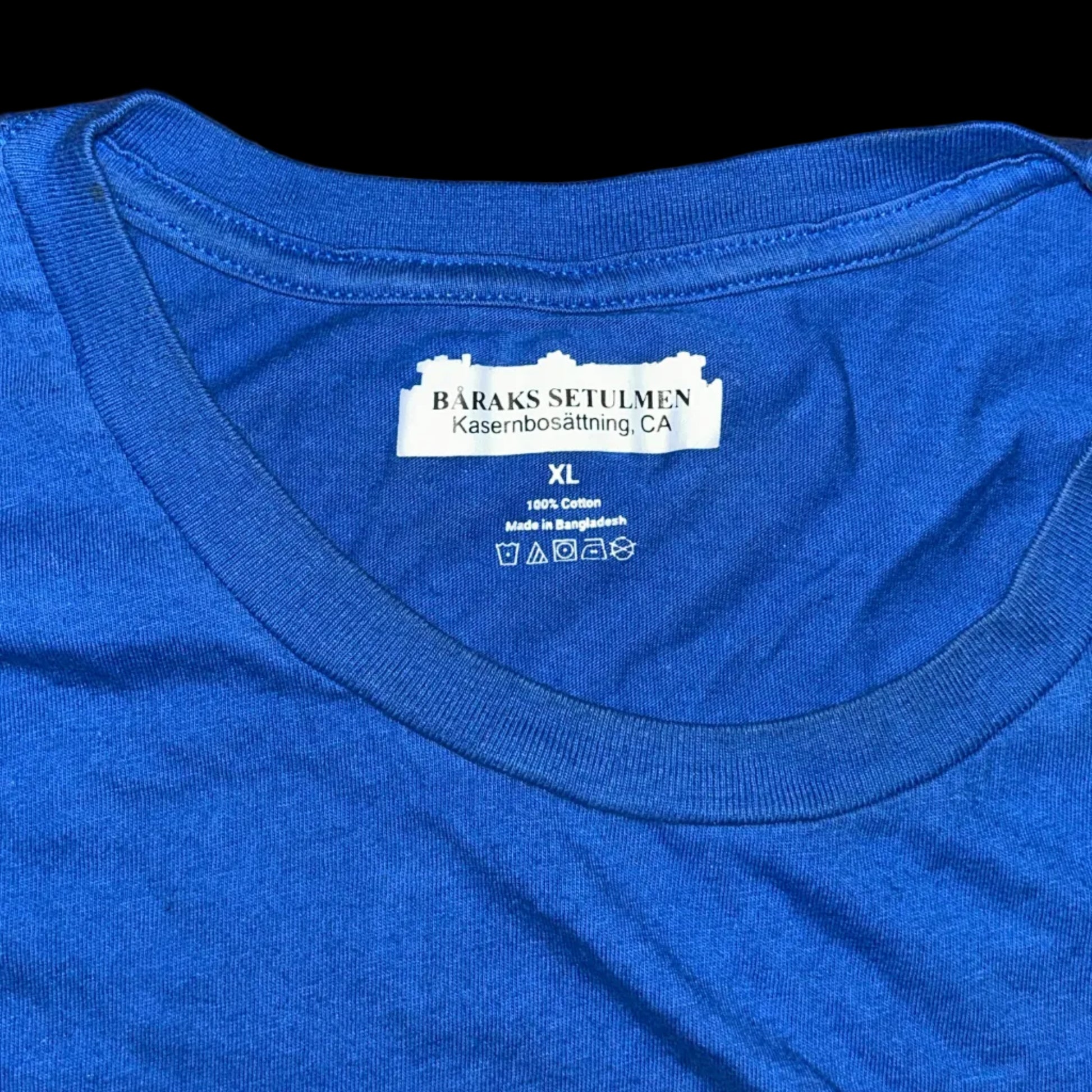 Blue t-shirt with a label on a wooden surface