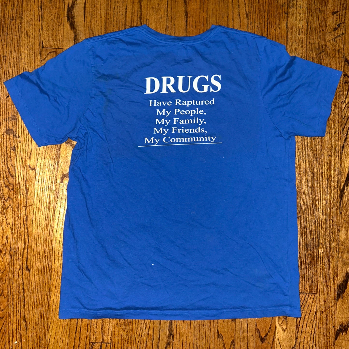 Blue t-shirt with text on a wooden surface