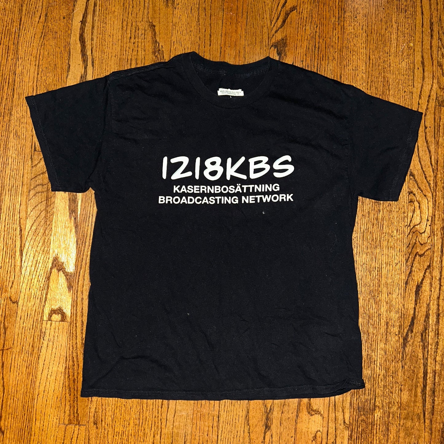 Black t-shirt with white text on a wooden surface