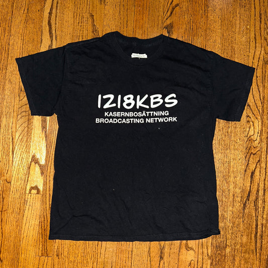 Black t-shirt with white text on a wooden surface