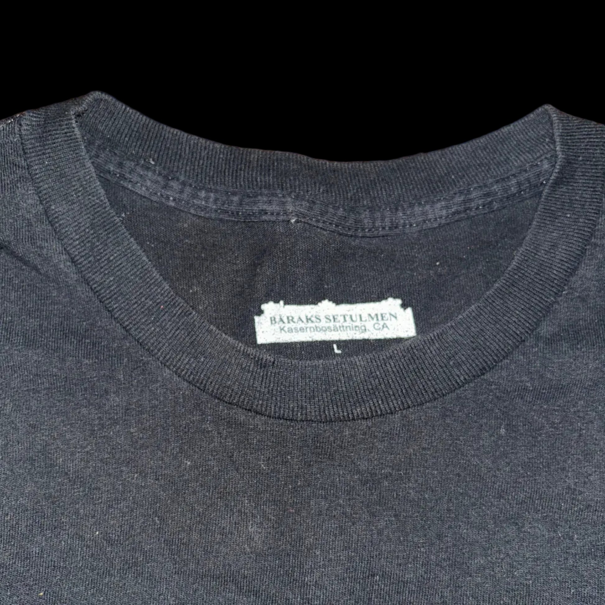 Black t-shirt with a brand label on a wooden surface