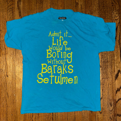 Blue t-shirt with yellow text on a wooden surface