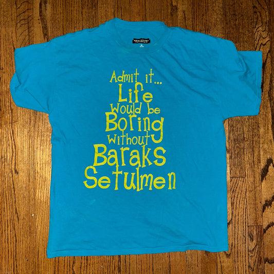 Blue t-shirt with yellow text on a wooden surface